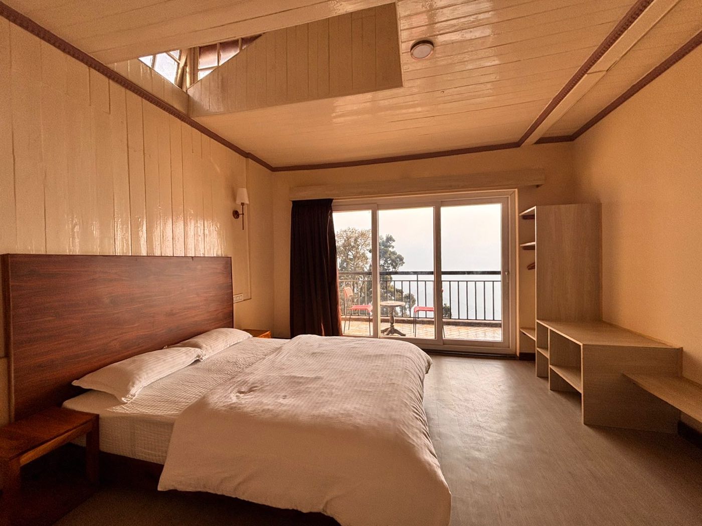 The Sylvia Coleridge room: pine-panelled walls, a skylight cut into the pitched roof, and red chairs on the balcony beyond