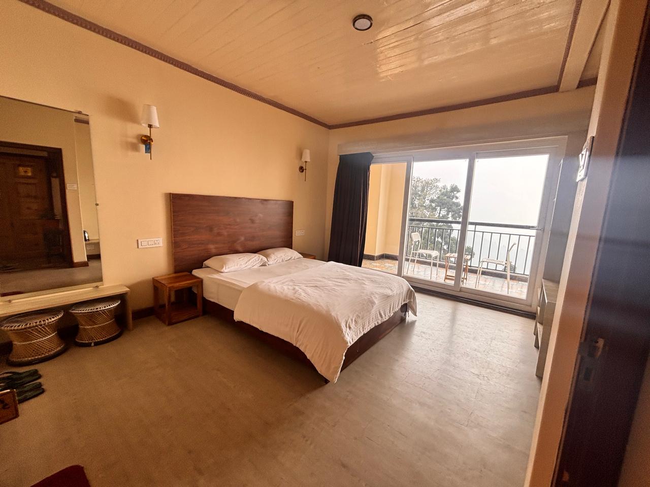The Vivien Leigh room: a corner room with wide balcony doors opening to mist over the valley